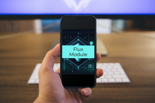 A hand holding a smartphone displaying a digital interface labeled 'Flux Module' against a blurred office background with a keyboard and monitor.